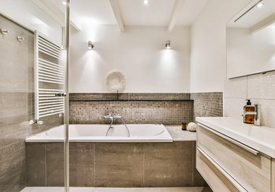 Bad mit eingebauter Badewanne, Mosaikfliesen und Handtuchheizkörper